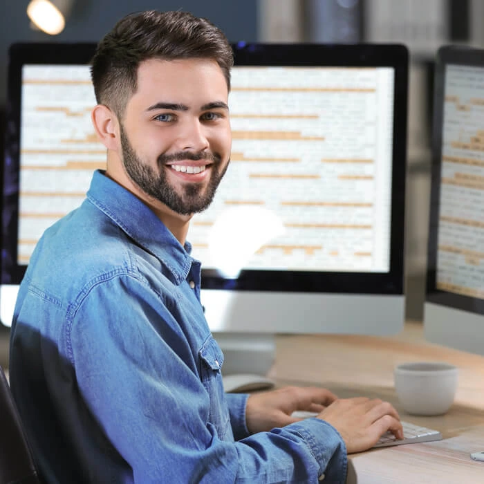 Two IT professionals, a man and a woman, looking at a laptop in a server room